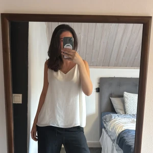 Vit linnetopp med smala axelband - Säljer en vit, flowy linnetopp med smala axelband som korsas i ryggen. Toppen har v-ringning fram och en snygg lös passform. Perfekt för varma dagar och enkel att styla med jeans eller kjol. Tröjan passar för dom som har storlek s och då blir tröjan lite som lose fit för dom som har storlek m/l så kommer tröjan sitta lite tajtare 💕