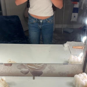 Blå lågmidjade jeans från Junkyard XS - Säljer ett par blå jeans från Junkyard i storlek XS. Jeansen har låg midja, klassisk femficksdesign och raka ben. Snygga kontrastsömmar och en enkel, tidlös look som passar till allt. Perfekta för dig som gillar en avslappnad och trendig stil.