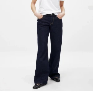 Mörkblå wide jeans med raka ben - Snygga mörkblå jeans med bred passform och raka ben. Klassisk femficksmodell med kontrastsömmar och låg midja. Populära från NA-KD, använda en gång! Säljer för de är för stora