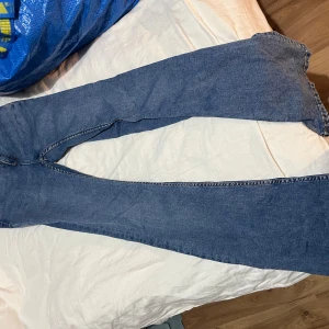 Blå bootcut jeans från 157, XS - Säljer ett par klassiska blå bootcut jeans från 157 i storlek XS Short. Jeansen har fem fickor, snyggt utställda ben och normalhög midja. Tillverkade i mjukt denimtyg som sitter skönt hela dagen. Perfekta för dig som gillar retrovibbar och avslappnad stil.