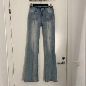 Ljusblå low waist bootcut jeans från Madlady - Snygga ljusblå bootcut jeans från Madlady med markerade sömmar framtill och stora fickor både fram och bak. Jeansen har låg midja och är extra långa, perfekta för dig som är lång. Original priset är 699kr