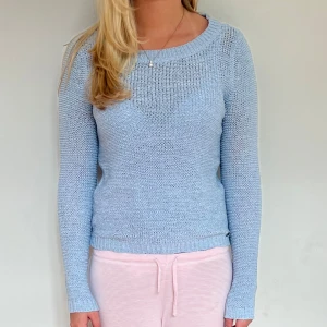 Ljusblå stickad tröja - Säljer en ljusblå stickad tröja med rund hals och långa ärmar. Materialet är lite ihåligt som man kan se på bild.