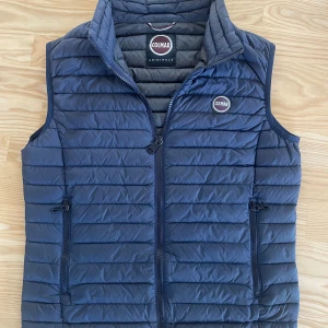 Mörkblå dunväst från Colmar - Säljer denna feta dunväst från Colmar. Perfekt att slänga över en hoodie för extra värme när det är kyligt ute. Ny pris 2200 mitt pris 850kr. Västen är i väldigt bra skick utan slitningar och defekter!                                                                   Hör av er om frågor mvh Loa