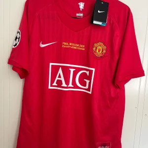 Manchester United Final Moscow 2008 tröja - Manchester Uniteds officiella matchtröja från Champions League-finalen i Moskva 2008. Röd med broderat klubbmärke, AIG-logga och Nike swoosh. Kortärmad, tillverkad i lätt Dri-FIT material som andas. Champions League-märke på ärmen och detaljer i gult och vitt.