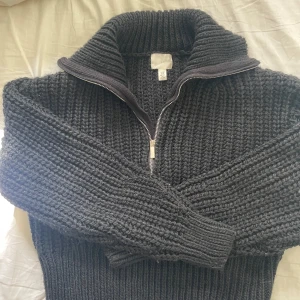 Svart stickad half zip-tröja - Mysig svart stickad tröja från H&M i storlek XS. Tröjan har en chunky ribbstickad struktur, hög krage och half zip-dragkedja framtill. Perfekt för kyliga dagar och enkel att styla. Säljer pga den inte kommer till användning🫰🏻
