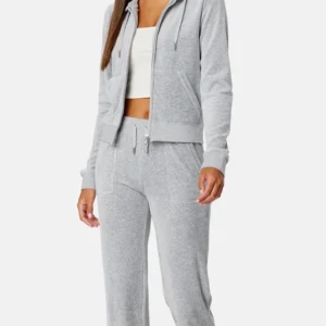 Grå juicy set  - Säljer ett par grå juicy set med bootcut och låg midja. Byxorna har snörning i midjan och är tillverkade i mjukt bomullsmaterial. Perfekta för chill dagar eller när du vill vara extra bekväm. Passar dig som gillar loose fit och sportig stil. De har ingen fläck men byxorna har ett litet hål i fickan som man inte tänker på och har använt de några fåtal gånger sitter väldigt fint men kommer inte till användning längre.