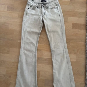 Levi's ljusa bootcut jeans - Snygga ljusa jeans från Levi's med bootcut passform. Jeansen har klassiska fem fickor, svarta kontrastsömmar och Levi's logga på bakfickan. Tillverkade i jeansmaterial och perfekta för dig som gillar en retro vibe.