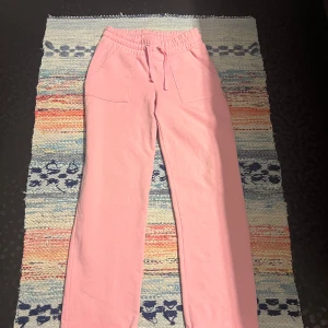 Rosa mjukisbyxor från 157, storlek S - Säljer ett par ljusrosa mjukisbyxor från 157 i storlek S. Byxorna har bred resår i midjan med snörning och två stora fickor fram. Sköna och chill med loose passform, perfekta för att hänga hemma eller dra till gymmet.