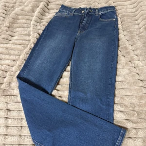 Blå jeans från Classx96 - Snygga blå jeans från Classx96 med klassisk femficksdesign och raka ben. Jeansen har hög midja och är tillverkade i ett mjukt denimtyg med ljusa tvättade partier. Perfekta för en avslappnad och trendig look.