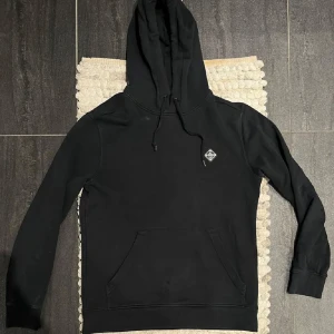Svart hoodie från J.Lindberg - Säljer nu denna snygga och ovanliga J.Lindberg hoodien i storlek M tröjan är använd men i övrigt har den fint skick skriv om ni vill ha fler bilder mått eller annat priset går att diskutera