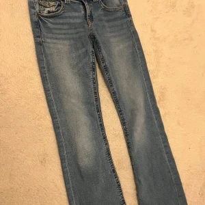 Low waist  bootcut jeans ifrån Gina Young - Ljusblåa bootcut jeans med mer rak passform och ganska låg midja har andvänds en gång och varan säljs inte längre köpt för 359kr strl 164/xs 