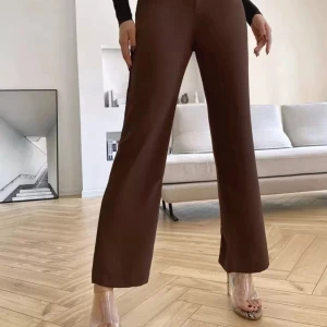 Bruna wide kostymbyxor - Snygga bruna kostymbyxor med wide passform och hög midja. Byxorna har klassiska bälteshällor och raka ben som ger en chill och trendig look. Perfekta att matcha med sneakers eller klackar för en clean stil. Materialet känns mjukt och har en lätt glans.