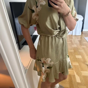 Blommig klänning Zara  - Jättefin grön/guld/beige klänning från Zara med blommor på! 🌸Storlek S men skulle tro att den passar M också 🩷