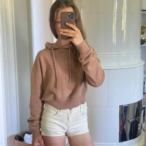 Beige/brun hoodie -  beige halvcroppad hoodie med långa ärmar och mjuk insida. Lagom tjockt tyg.