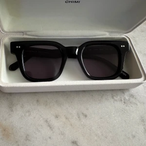 CHIMI 04 - Snygga svarta solglasögon från CHIMI med mörka glas. Perfekta för dig som gillar stilrena accessoarer.