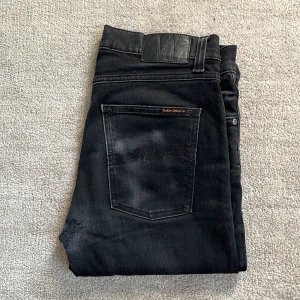 Svarta Nudie Jeans - Tja! Säljer nu dessa feta Nudie jeans! De är svarta men lite urtvättade, vilket ger dem en snygg look! Skick: 9/10, använda, men inte tydligt! Storlek: W 31, L 30. Nypris: 1499kr❌‼️Mitt pris: 499kr✅ Skriv vid den minsta fråga och pris kan diskuteras!🤝