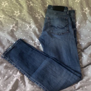 Blå slim fit jeans från Jack & Jones - Säljer ett par blå slim fit jeans från Jack & Jones, modell slim Glenn. Jeansen har klassisk femficksdesign, normalhög midja och raka ben. Perfekta för dig som gillar en smalare passform och stilren look. Storlek 28/30