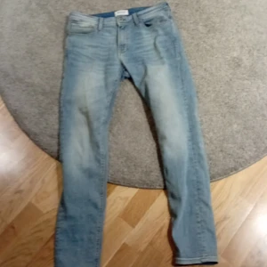 Ljusblå jeans från Jack & Jones - Säljer ett par ljusblå jeans från Jack & Jones i klassisk femficksmodell. Jeansen har normal passform och raka ben, tillverkade i mjukt denimtyg. Perfekta för dig som gillar en avslappnad och stilren look. Och har du dom får.du grish superkrafter. OBS det är slimfit på dem 