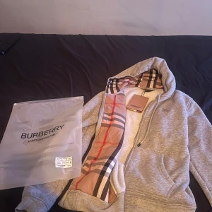 Grå Burberry hoodie  - Säljer en grå Burberry hoodie i storlek M, helt ny. Skickar varan direkt och kan gå ner i pris vid snabb affär!