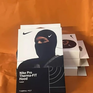 Nike Ski mask - 📦 Nike Pro Therma-FIT Hood – NY & OANVÄND  ✅ Original Nike-produkt ✅ Värmande Therma-FIT-teknologi ✅ Perfekt för fotboll, träning & vinter ✅ Stretchig, tight passform – idealisk under hjälm/jacka ✅ Levereras i obruten förpackning 🌍 EXKLUSIV – finns ej i butik i Sverige  📍 Finns i Sthlm 📬 Skickas eller hämtas 📦 Flera i lager – mängdrabatt vid köp av fler