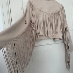 Beige mockajacka med fransar från Zara - Garderobsrensning pågår! 👗 Shoppa loss bland en massa fina plagg, allt blandat från Y2K, vintagekläder, jeans, kjolar, klänningar, jackor, toppar och assessorer.  Kika in på min sida, så kanske du hittar något mer du gillar!  Har du frågor om ett plagg? Tveka inte att höra av dig!  (OBS: Kan tyvärr inte ta bilder med plaggen på.)