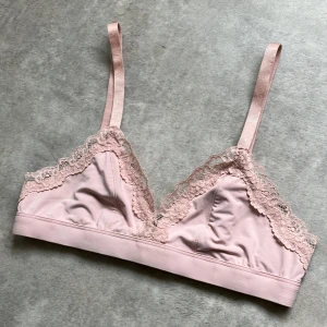 Rosa spets bralette från Lager 157 - Säljer en ljusrosa bralette från Lager 157. Mjuk och bekväm modell med justerbara axelband och hakknäppning bak. 