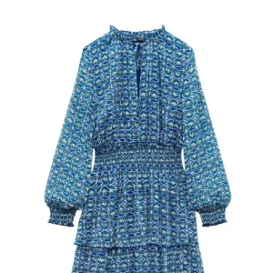 Blå mönstrad kortklänning från Zara - Supersöt blå kortklänning från Zara med vitt och grönt mönster, långa ärmar med smock vid handlederna och markerad midja. Klänningen har v-ringning och volangdetaljer i kjolen. Perfekt för midsommar eller bara en fin sommar outfit.