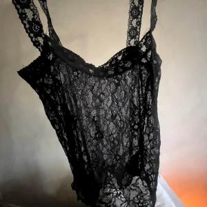 Svart spetslinne från Nelly - Säljer ett snyggt svart spetslinne från Nelly. Linnet har smala axelband och en elegant spetsdesign som ger en stilren look. Perfekt för att lägga till en touch av elegans till din outfit. 🖤