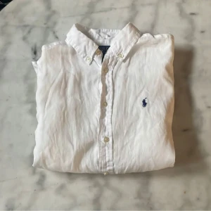 Vit linneskjorta från Ralph Lauren - Säljer min linneskjorta från Ralph lauren. Skjortan är använd ett fåtal gånger och i stort sätt nyskick. 9/10 skick. Storleken är 14-16 years men sitter som en vanlig S. Hör av er vid minsta funderingar🙏 