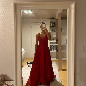 Röd balklänning med smala axelband - Hjälper nu min vän att sälja två av sina balklänningar och detta är den första!🙌🏽 Endast använd en gång till studentbalen förra året. Dock finns små vita fläckar vid nedre delen av klänningen som man knappt lägger märke till🫶🏽 Storlek M, dock liten i storleken