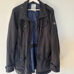 J Lindberg fieldjacket - Tjena säljer denna fieldjacket från J Lindberg. Jackan är i storlek M men kan dras åt runt midjan. Inga defekter och i bra skick. Perfekt jacka nu för våren! Kan gå ner i pris om smidig affär 
