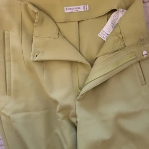 Ljusgröna byxor från Stradivarius - Snygga ljusgröna byxor från Stradivarius med hög midja och dragkedja framtill. Byxorna har en stilren design med diskreta fickor på sidorna. Perfekta för en chic och modern look.