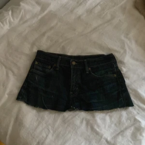 Jeansshorts från Levi's - Säljer ett par klassiska jeansshorts från Levi's. De är mörkblå och har den ikoniska röda Levi's-loggan vid bakfickan. Perfekta för en avslappnad stil.