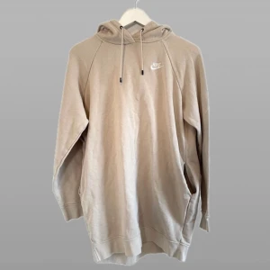 Beige hoodie från Nike Stl S - Säljer en stilren beige hoodie från Nike med klassisk logga på bröstet. Tröjan har en bekväm passform med långa ärmar och justerbar huva. Perfekt för en avslappnad look.