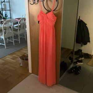 korallfärgad långklänning från NLY eve - Säljer en korallfärgad långklänning från NLY Eve. klänningen har smala axelband. den är helt oanvänd men det är för stent att lämna tillbaka. perfekt bal klänning. pris kan alltid diskuteras 