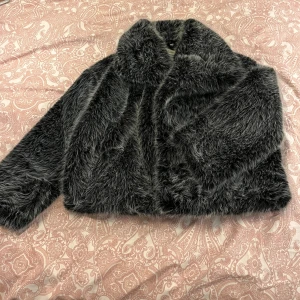 Grå päls jacka  - Grå pälsjacka. Med fickor och knappar så man kan stänga. Använd 2 gånger.