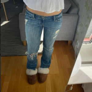 Hollister lågmidjade bootcut jeans med hål - Sjuukktt snygga lågmidjade bootcut jeans med hål i från hollister😍 Köpte här på plick men dem var tyvvär för små. Midjemått:38 cm rakt över, innerbenslängd: 82cm GÅR NER I PRIS VID SNABBT KÖP, POSTAR DIREKT (säljer inte under 800)