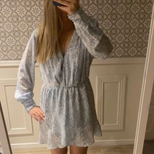 Blommig ljusblå klänning - Söt ljusblå klänning från Nelly, använd 2/3 gånger och kommer inte till användning längre. 