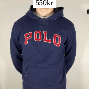 Blå hoodie från Ralph Lauren - Säljer en snygg blå hoodie från Ralph Lauren med röd POLO-text på bröstet. Perfekt för en avslappnad stil. Hoodien har en klassisk passform och en bekväm huva. Perfekt för kyliga dagar! Passform XL för barn vilket motsvarar runt M i herr. Kom med frågor!