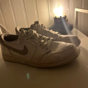 Nike Air Jordan 1 Low OG i vitt och grått - Säljer ett par Nike Air Jordan 1 Low OG i vitt med grå detaljer. Skorna har klassisk snörning och en stilren design som passar perfekt för ett par vardagsskor. Skorna har använts en del gånger, därav priser men de är köpta för 2700. Tveka inte att höra av dig vid fler frågor!