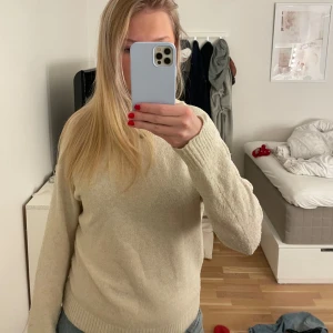 Beige stickad tröja - Säljer en mysig beige stickad tröja med långa ärmar och ribbstickade muddar. Perfekt för kyligare dagar. Passar bra till jeans eller kjol. Hör av dig vid intresse!