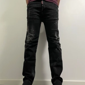 Svarta jeans från Dsquared2 - Svarta jeans från Dsquared2 med en sliten still. De har en klassisk femficksdesign och en diskret logga på fickan.  Storlek: 52 men passar för 50/54 också. Inget kvitto ingår i köpet och därför kan jag gå ner i några hundralappar i pris! 