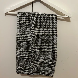 Svartvit rutig trousers från HM - Snygg svartvit rutig trousers från H&M i klassiskt mönster. Perfekt för en stilren look. Kjolen har en normal passform och är tillverkad i ett bekvämt material.