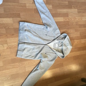 Grå hoodie från Jack & Jones Avslappnad - Säljer en stilren grå hoodie från Jack & Jones. Den har en dragkedja framtill och en bekväm huva med snörning. Perfekt för en avslappnad look. Passar bra till jeans eller joggers. Aldrig använd pga för stor för mig. Storlek S passar bra 175-185 längd pris kan diskuteras.
