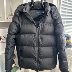 Svart pufferjacka från Polo Ralph Lauren - Tja! Säljer denna Ralph Lauren jacka för att den inte kommer till användning längre. Jackan är som ny och har mycket kvar att ge. Skriv gärna vid fundering. Kan även gå med på byten!🤗