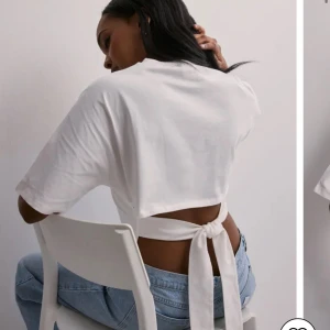 Vit kortärmad topp med knyt - Säljer en stilren vit topp med korta ärmar och knytning i ryggen. Perfekt för en avslappnad look med en twist. Passar bra till jeans eller kjol.