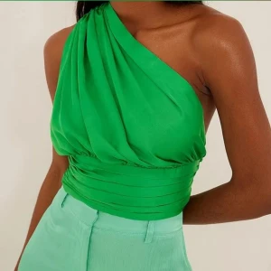 Festtopp - Snygg glansig grön festtopp från nakd i storlek 36. Oanvänd och måste sälja för att den är för liten i midjan för mig.