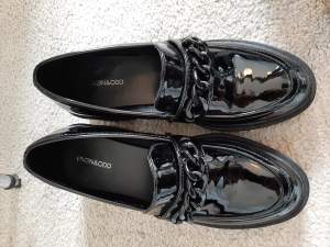 Stilrena och eleganta platå-loafers, nästan oanvända i svart lack.