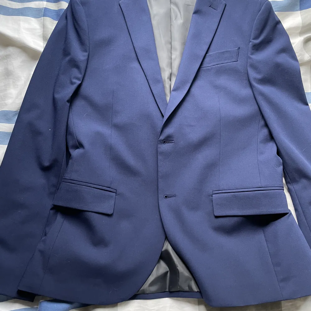 Säljer nu min Mörkblåa kostym från dressman då den blivit för liten! Använd 3ggr så inga tydliga tecken på användning alls. Nypris 2400kr! Byxorna är storlek 30/30 men och kavajen är storlek 48! Den passar någon som är runt 170cm! Hör av er vid frågor!. Kostymer.