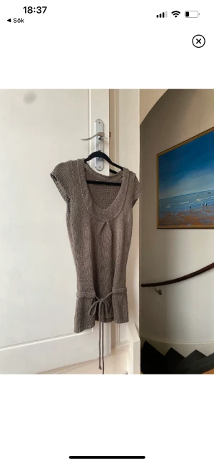 Stickad topp - Stickad brun/beige topp med snörning i midjan. Bra skick! Som en storlek S (står ej storlek) 